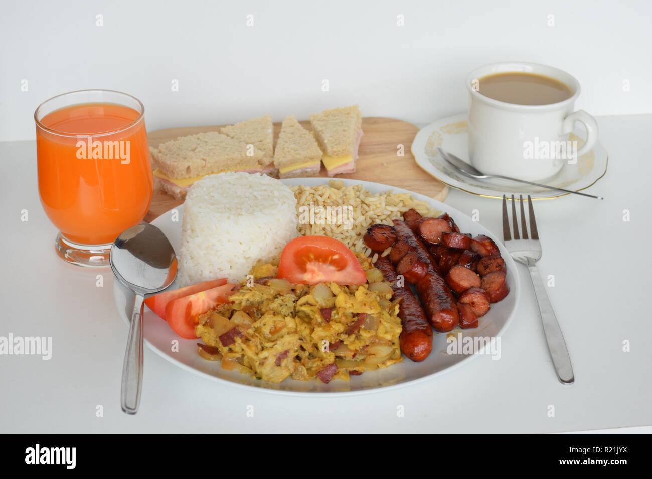 A freshly cooked breakfast of egg, bacon, sausage, tomatoes and rice at Lety’s Transient Homes Baguio. Ein frisch zubereitetes Frühstück mit Ei, Speck Stock Photo