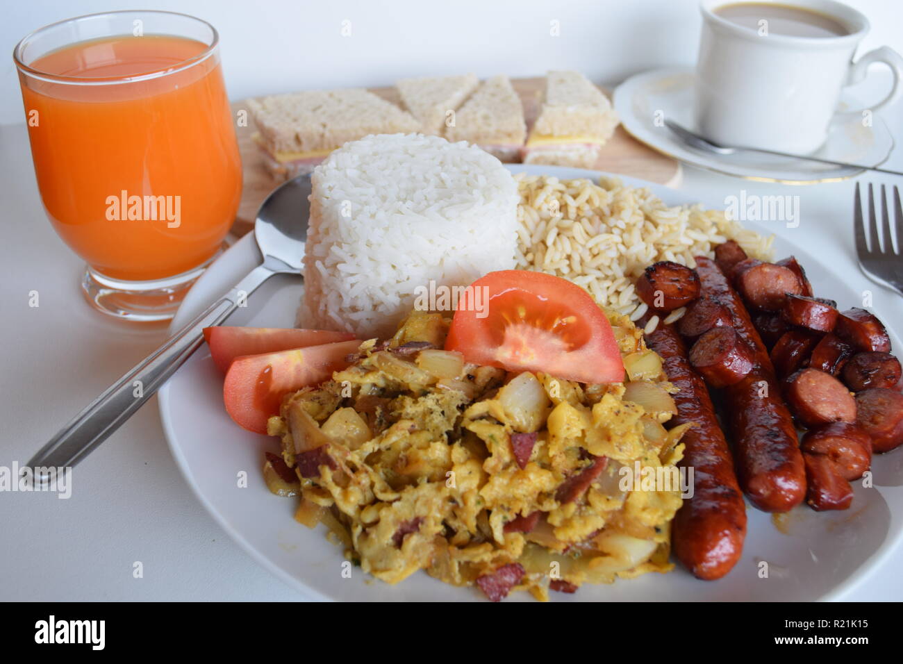 A freshly cooked breakfast of egg, bacon, sausage, tomatoes and rice at Lety’s Transient Homes Baguio. Ein frisch zubereitetes Frühstück mit Ei, Speck Stock Photo