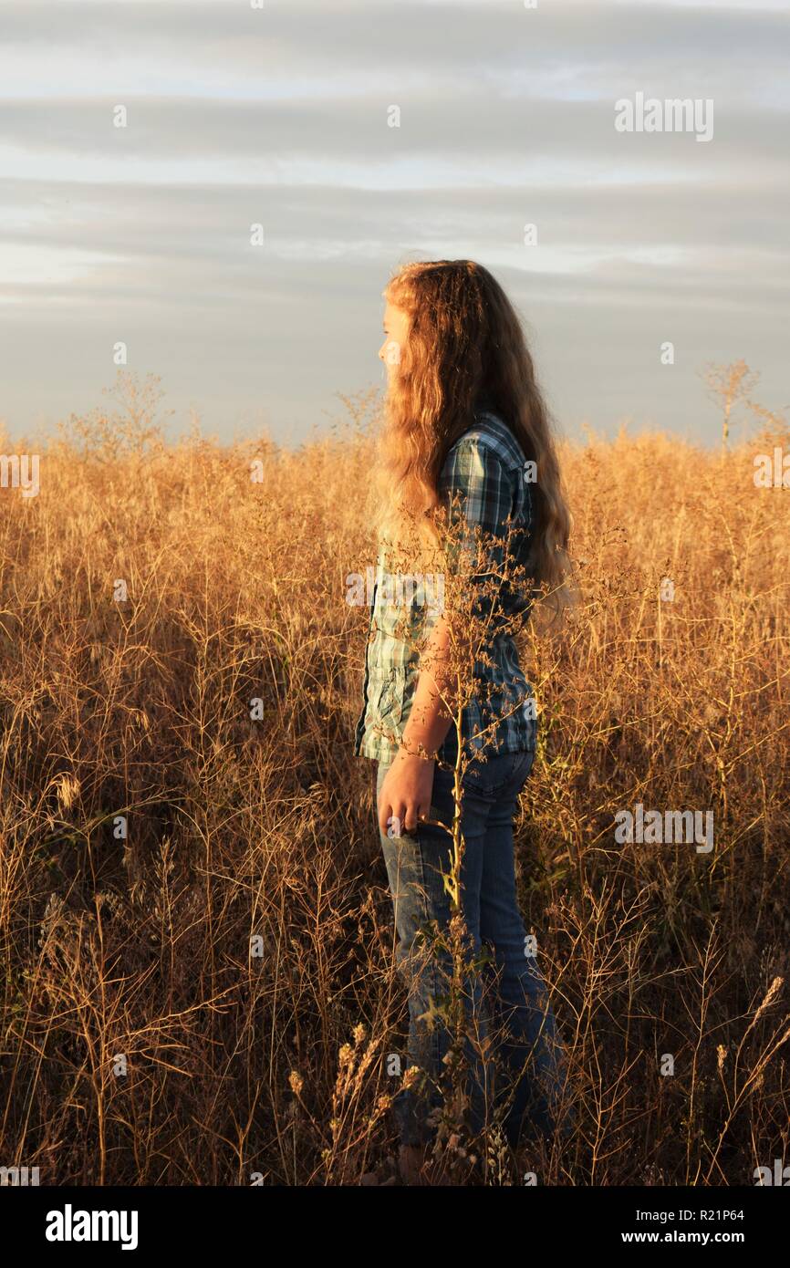 Girl in Field During Sunset Stock Photo - Alamy