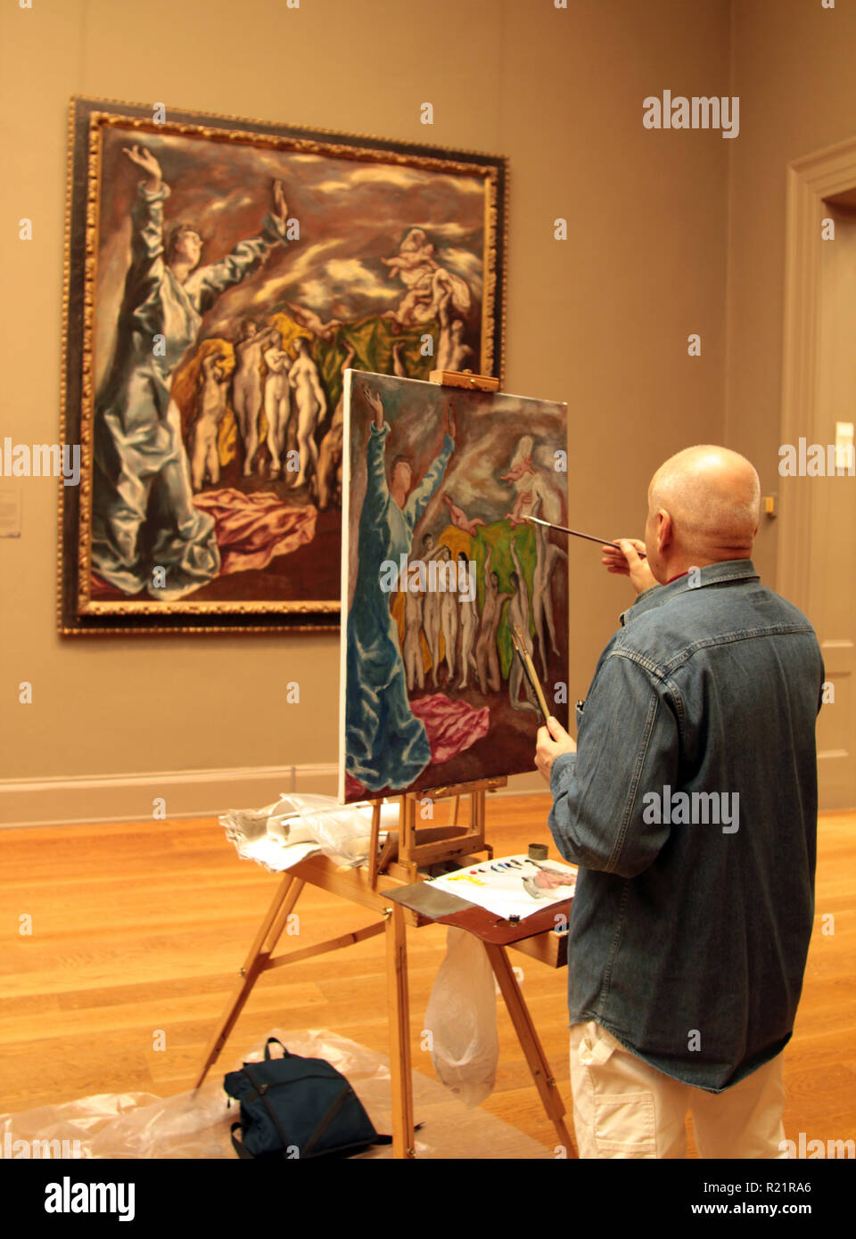 A keen amateur artist is practising his skills by copying a painting in the Metropolitan Museum of Art in New York Stock Photo