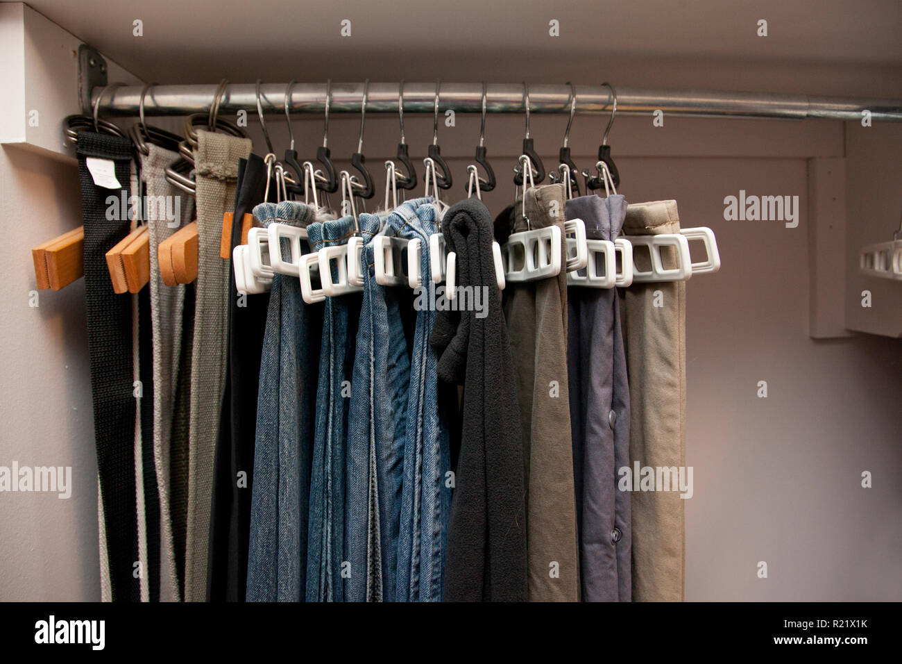 Pairs Of Jeans And Pants Hang On Hangers In A Row In The Closet Well