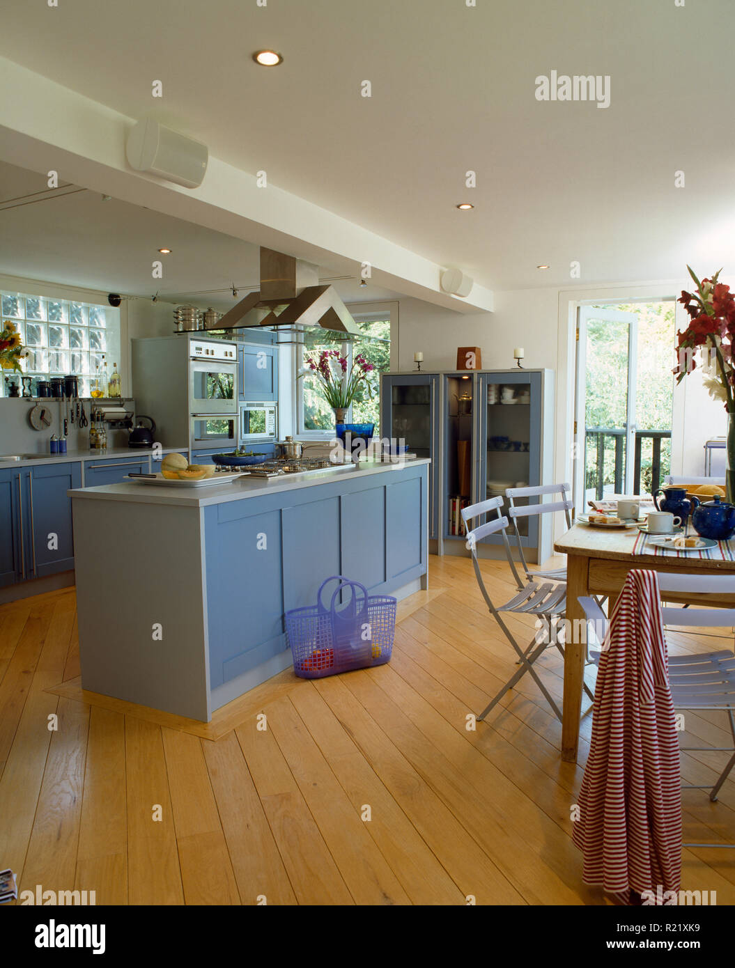 Pale blue doors on island unit in modern kitchen with wooden floor Stock Photo