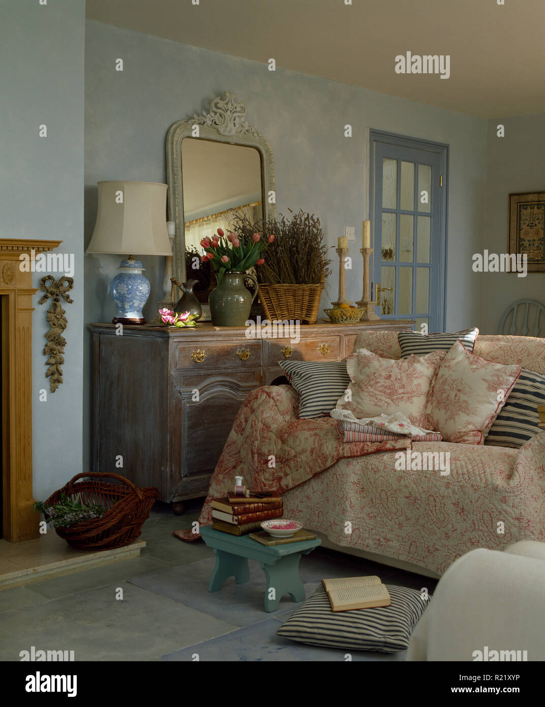 Cushions And Quilts On Sofa In Country Sitting Room Stock Photo