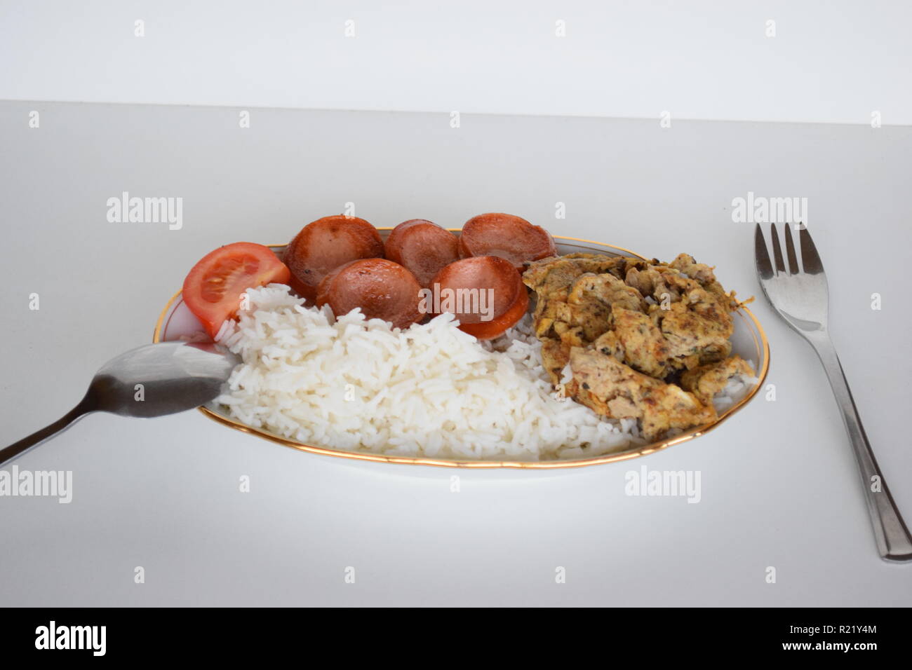 A freshly cooked breakfast of egg, Lyoner sausage, tomatoes and rice at Lety’s Transient Homes Baguio, B&B. Ein frisch zubereitetes Frühstück Stock Photo