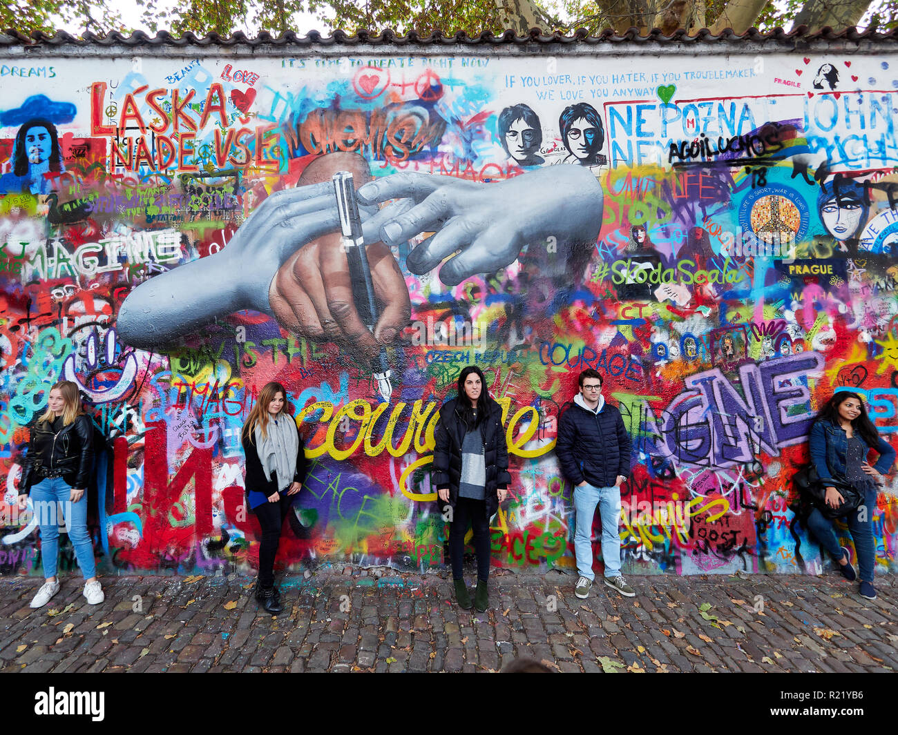 Prague, Czech Republic - October 31, 2018 Tourists pose for a photo in front of the John Lennon wall. Stock Photo