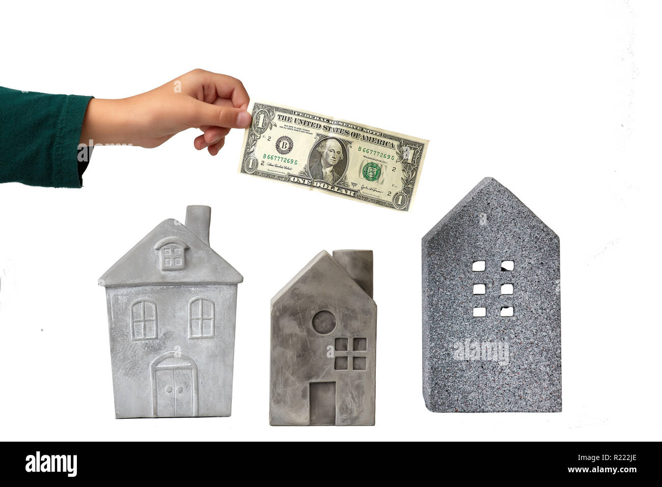 Crop hand holding money over houses Stock Photo
