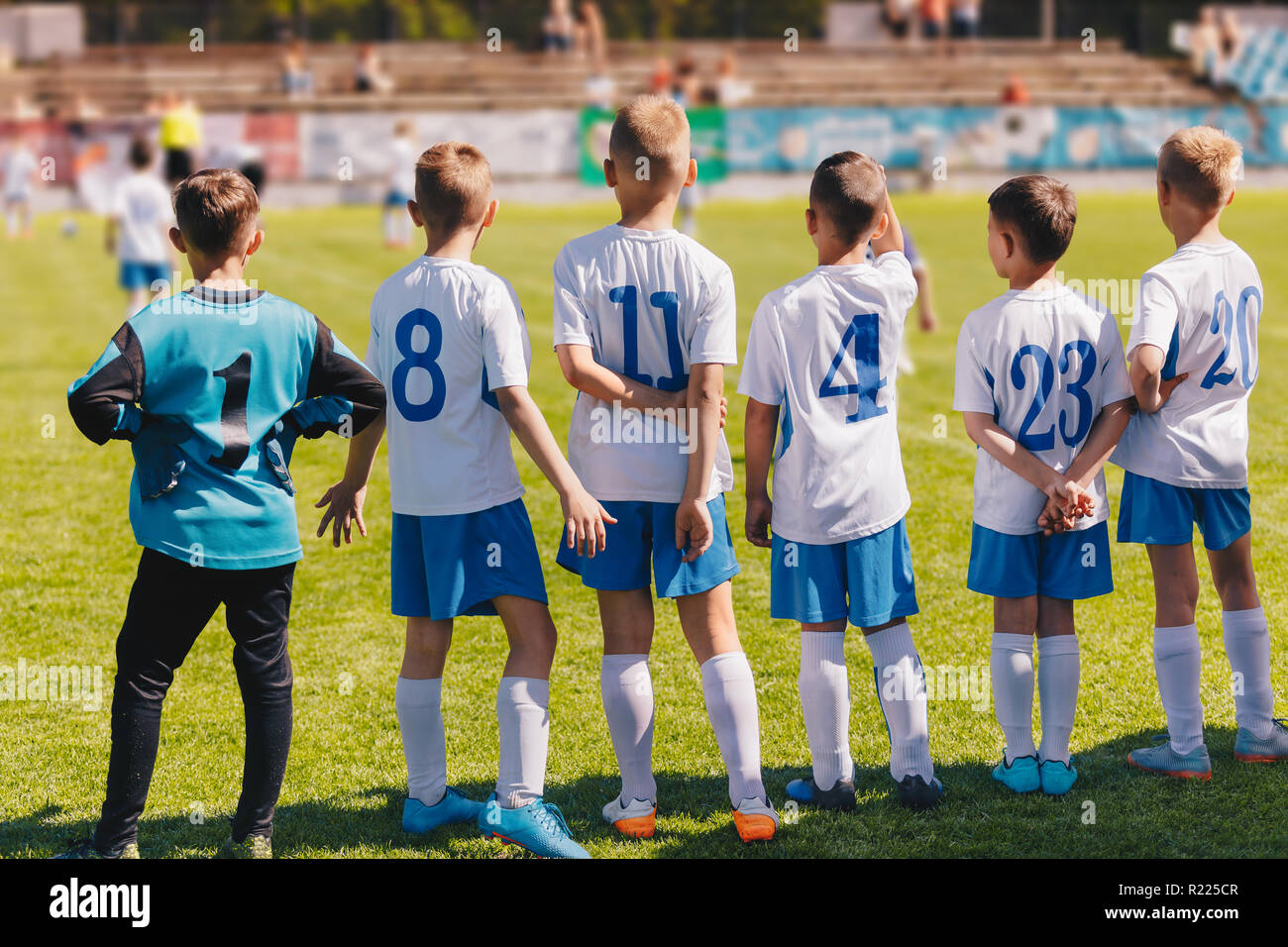 Children Sport Team Photo. Group of Young Boys Playing Soccer Tournament Match. Football Soccer Game For Children. Kids Soccer Players Standing Back o Stock Photo