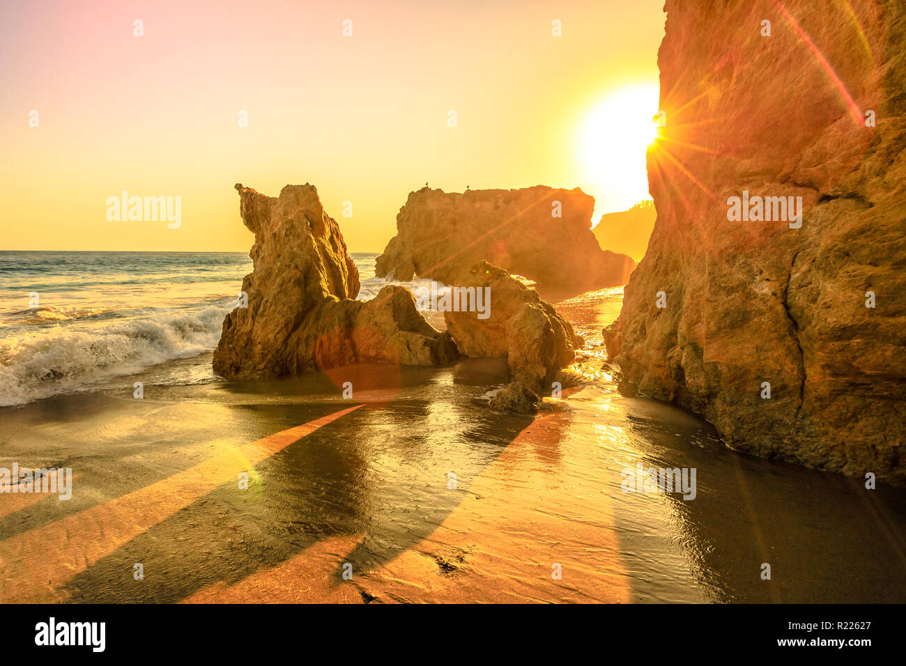 El Matador State Beach, California, United States. Sunbeams with sunset lights between pillars and rock formations of most photographed and scenic of Malibu beach, Pacific Ocean. California West Coast Stock Photo
