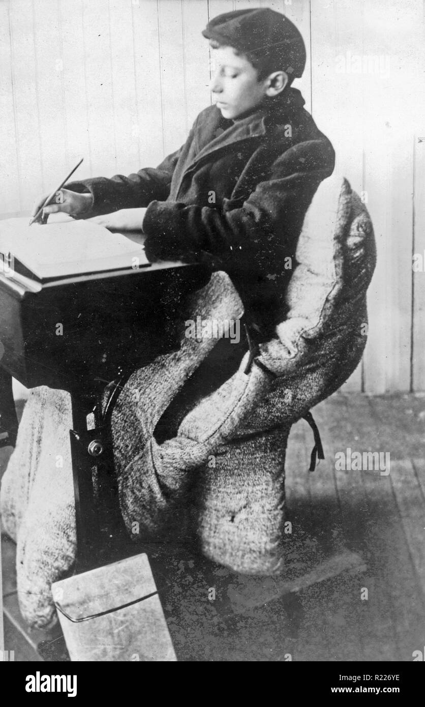 Pupil in open-air school, Providence; Boy seated at desk in sleeping bag 1912 Stock Photo
