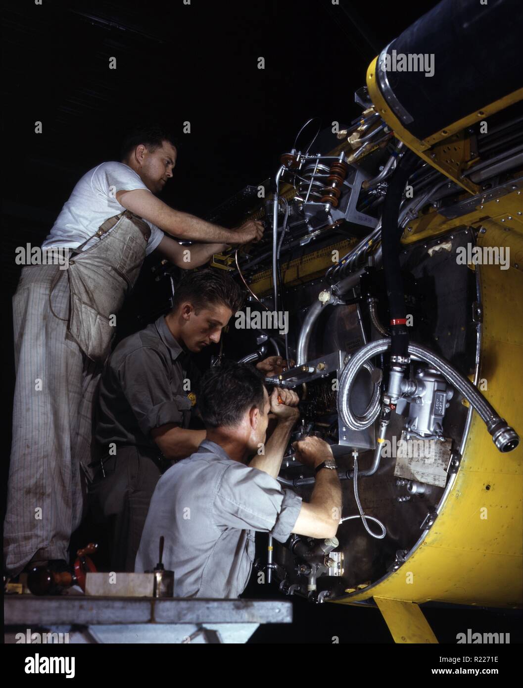 Making wiring assemblies at a junction box on the fire wall for the right engine of a B-25 bomber, North American Aviation, Inc., [Inglewood], Calif. 1942 Stock Photo