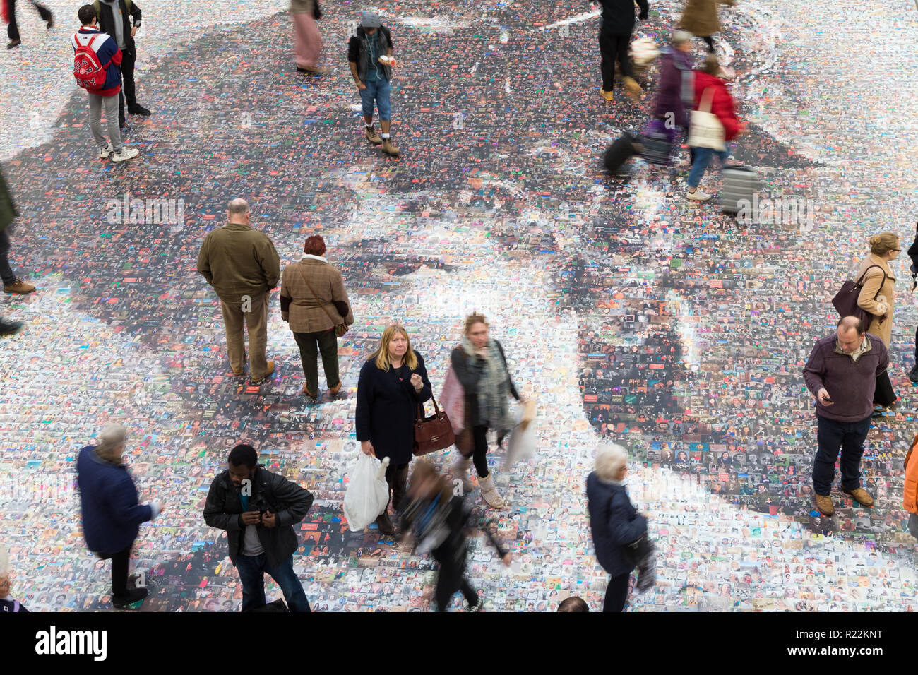 Birmingham, UK. 16th November, 2018. A large-scale mosaic portrait of sufragette Hilda Burkitt is on show on the concourse floor of New Street station, Birmingham. The 20 metre portrait is made up of 3,724 selfie photographs and other photographs of women sent in from all over the UK. The project, called Face of Suffrage, is deisgned by artist Helen Marshall. Hilda Burkitt was born in Wolverhampton in 1876, was convicted and jailed for breaking a window in the then Prime Minister's train carriage. Peter Lopeman/Alamy Live News Stock Photo