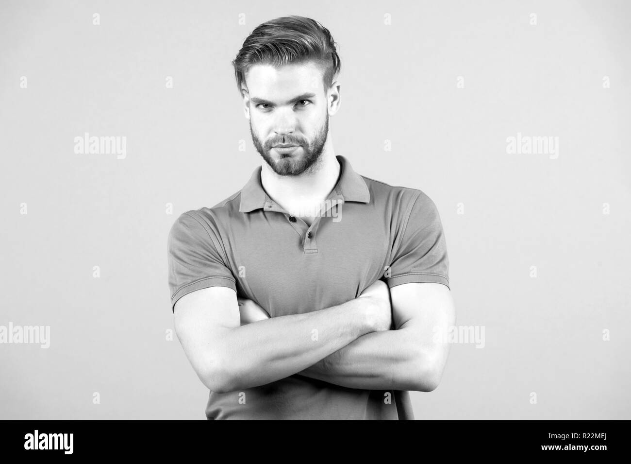 Macho with folded hands in blue tshirt, fashion. Man with bearded face, blond hair, haircut. Fashion, style, trend. Barber salon, barbershop. Grooming beauty hair care Stock Photo