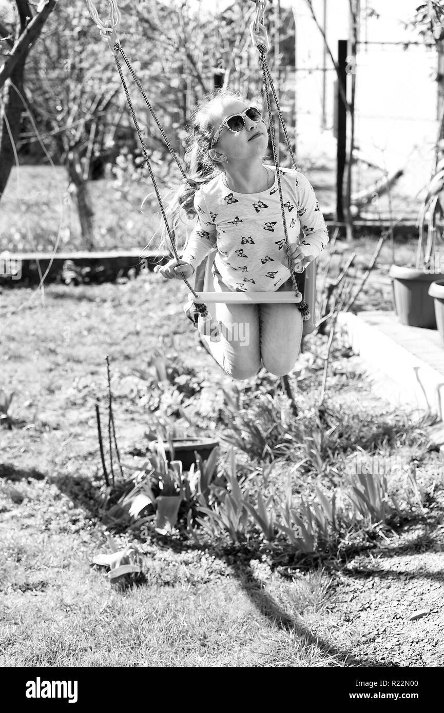 Fashion Girl In Sunglasses Enjoy Swinging On Sunny Day