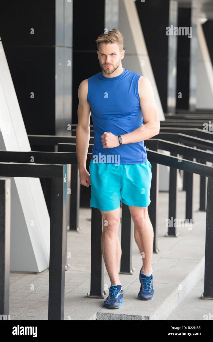 On way to success. Sportsman training with pedometer gadget at stadium ...