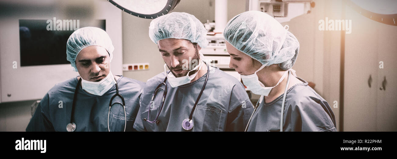 Surgeons discussing over digital tablet in operation room Stock Photo