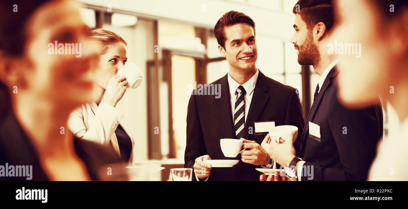 Businesspeople interacting with each other while having coffee Stock Photo