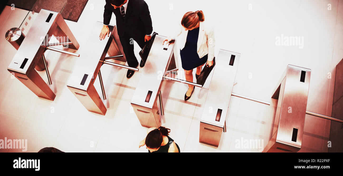 Business executives passing through turnstile gate Stock Photo
