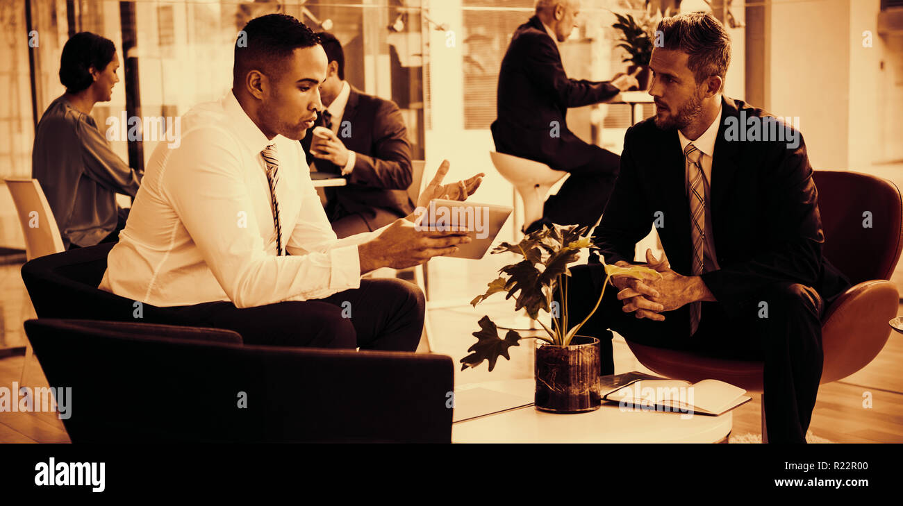 Businessmen having discussion over digital tablet Stock Photo