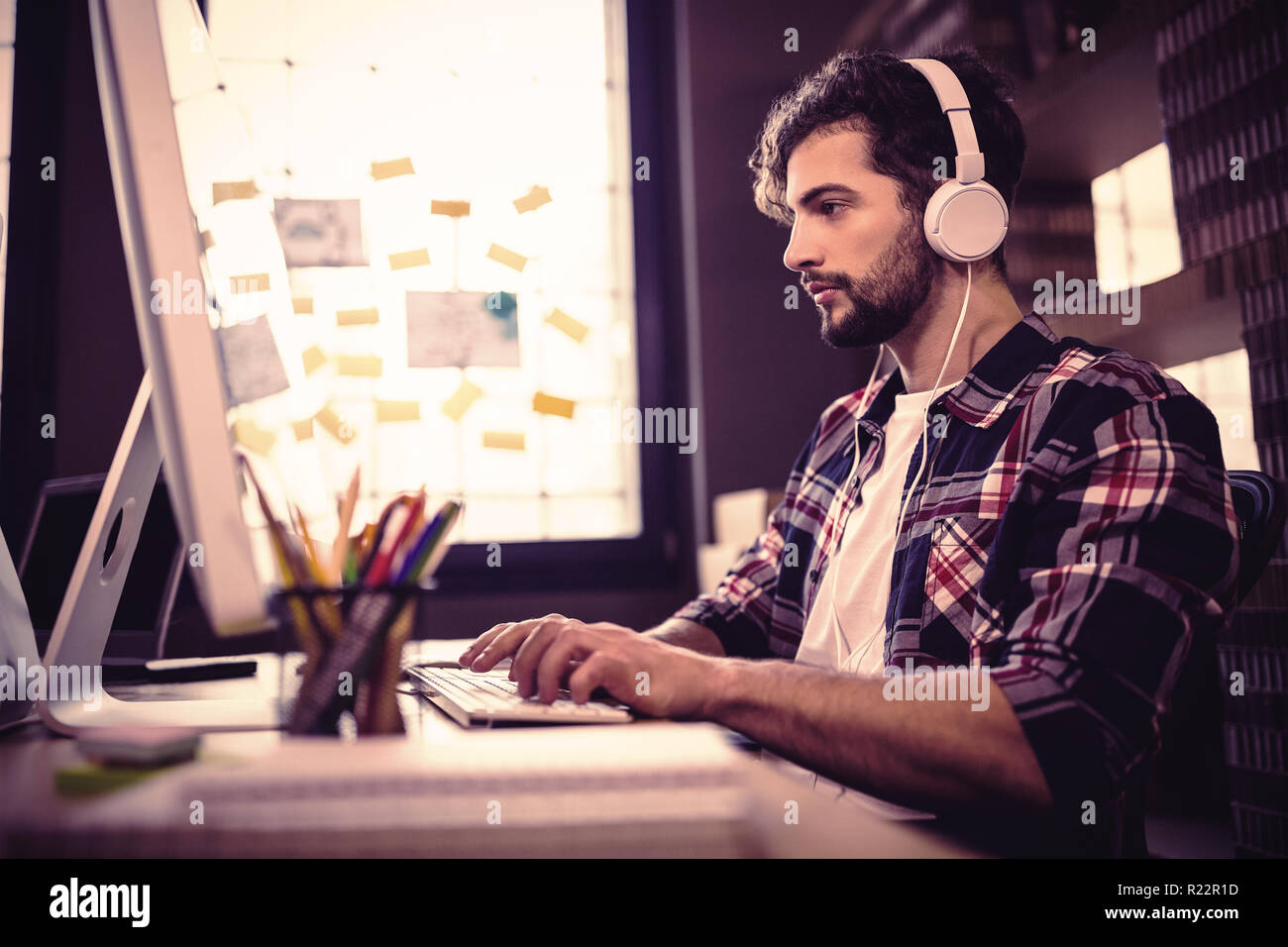 Creative businessman using computer while listening music Stock Photo