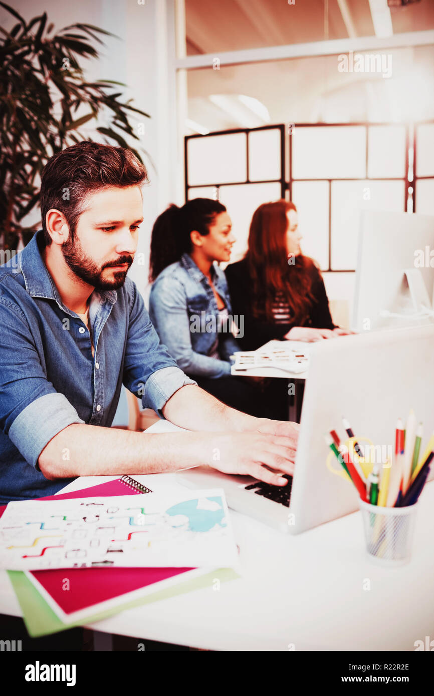 Creative business people using technologies at desk Stock Photo