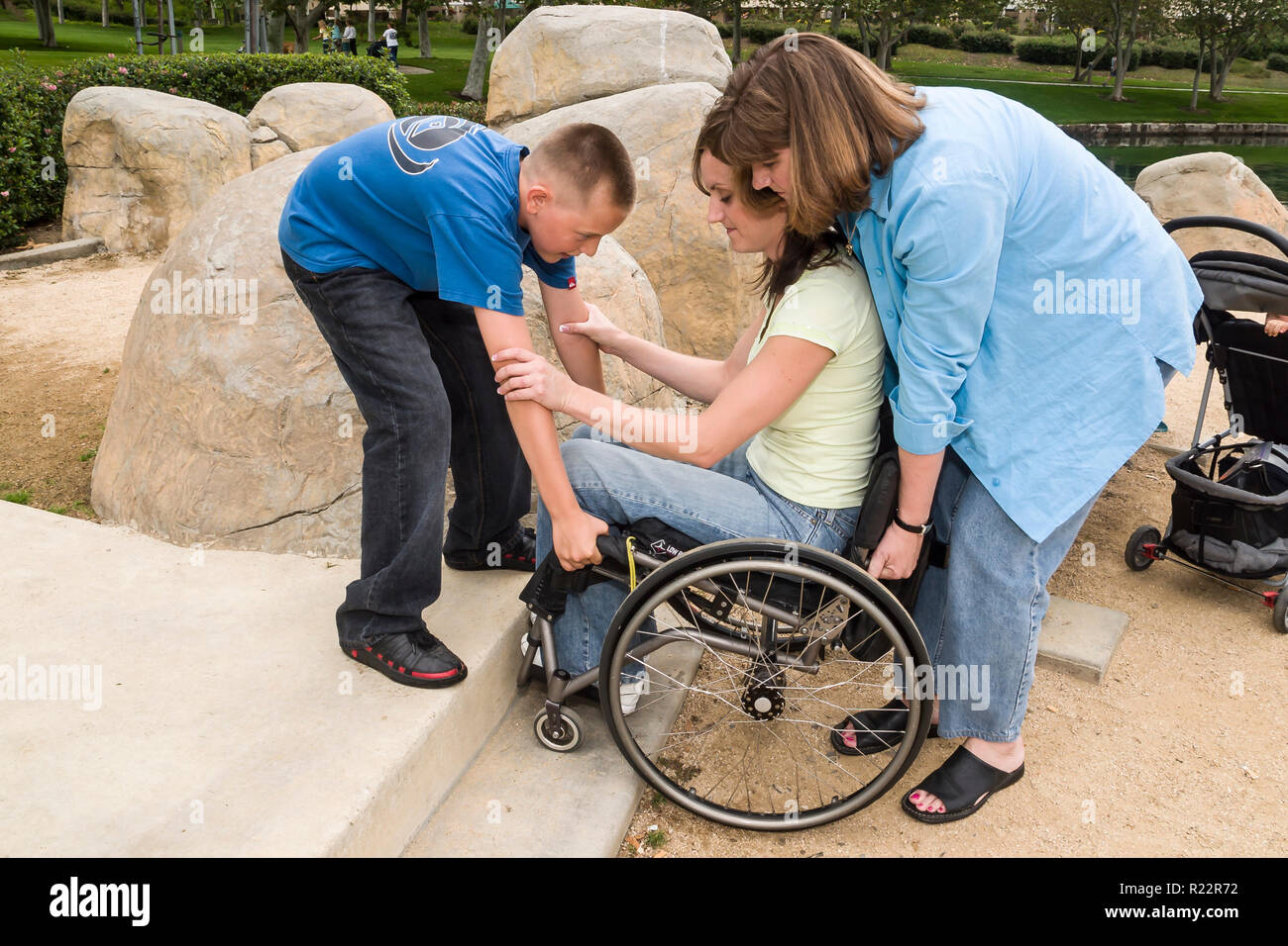 Boy helping his aunt lift his mother up a step in the park. MR  © Myrleen Pearson   ...Ferguson Cate.  Series of 4 images Stock Photo