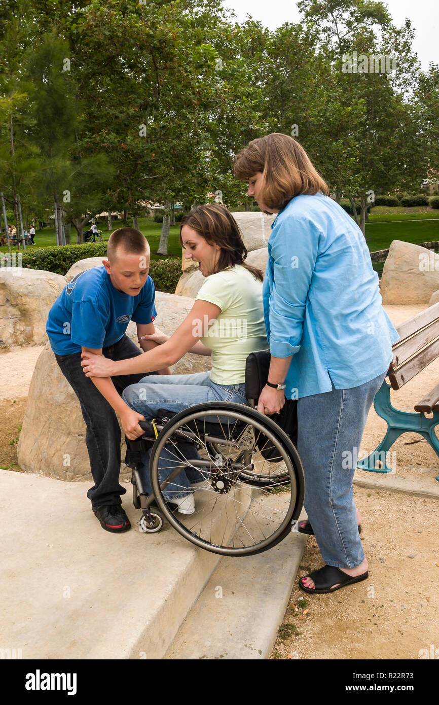 Boy helping his aunt lift his mother up a step in the park. MR  © Myrleen Pearson   ...Ferguson Cate  Series of 4 Stock Photo