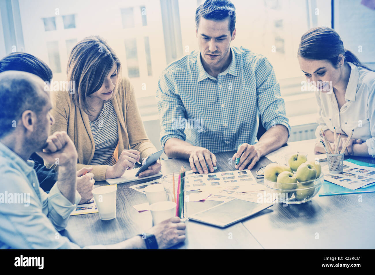 Editors with documents working in meeting room Stock Photo