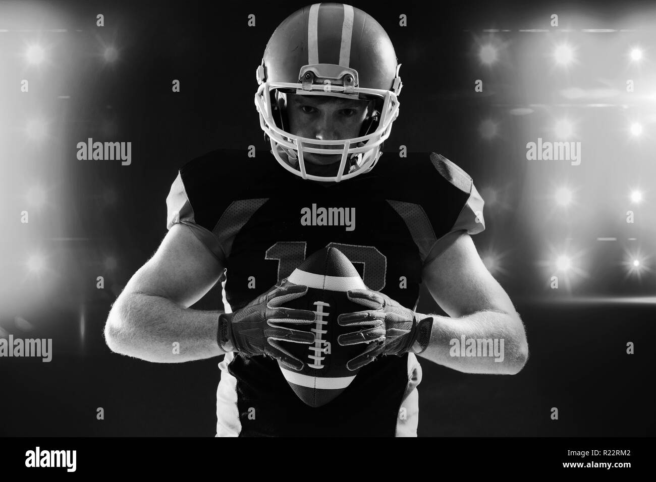 American football player in helmet holding rugby ball Stock Photo Alamy