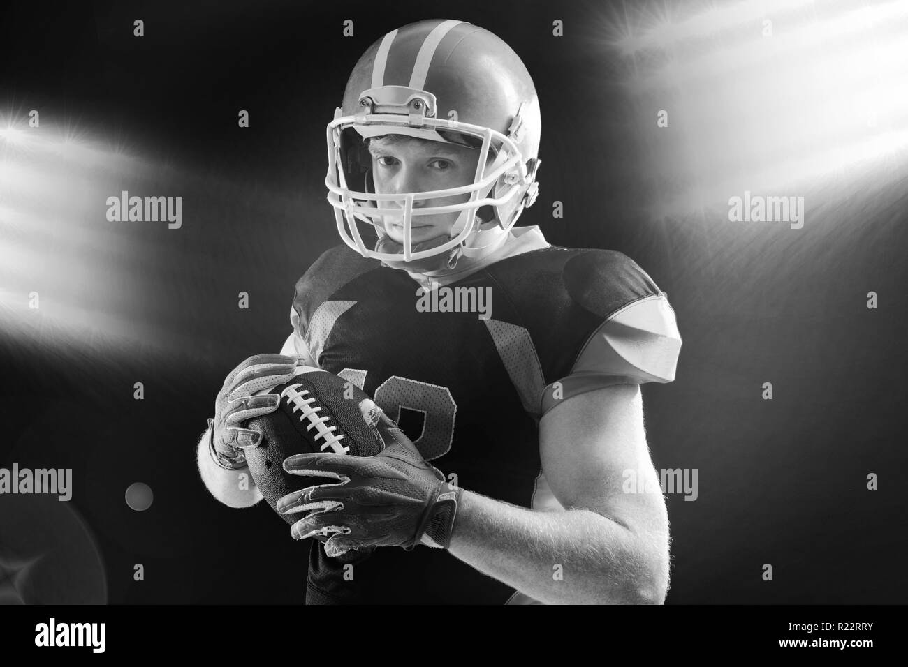 American football player in helmet holding rugby ball Stock Photo Alamy
