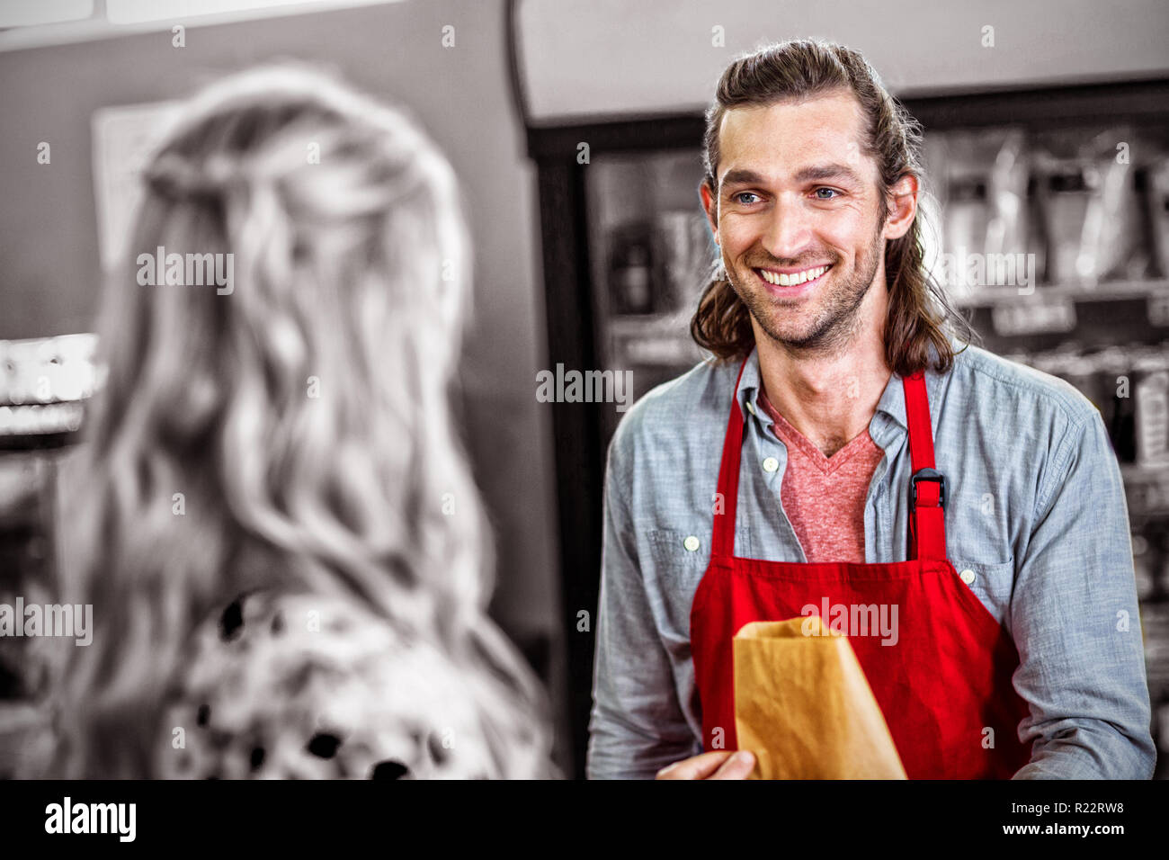 Male staff interacting with woman in supermarket Stock Photo