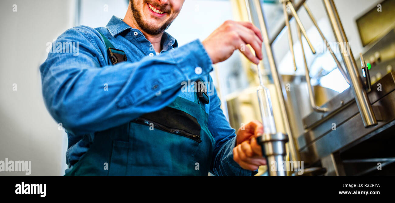 Brewer checking beer with hydrometer Stock Photo