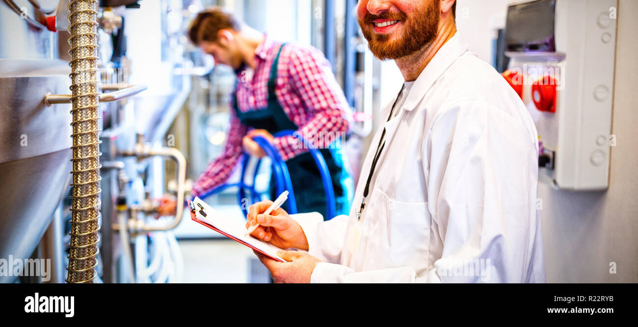 Maintenance workers examining brewery machine Stock Photo Alamy