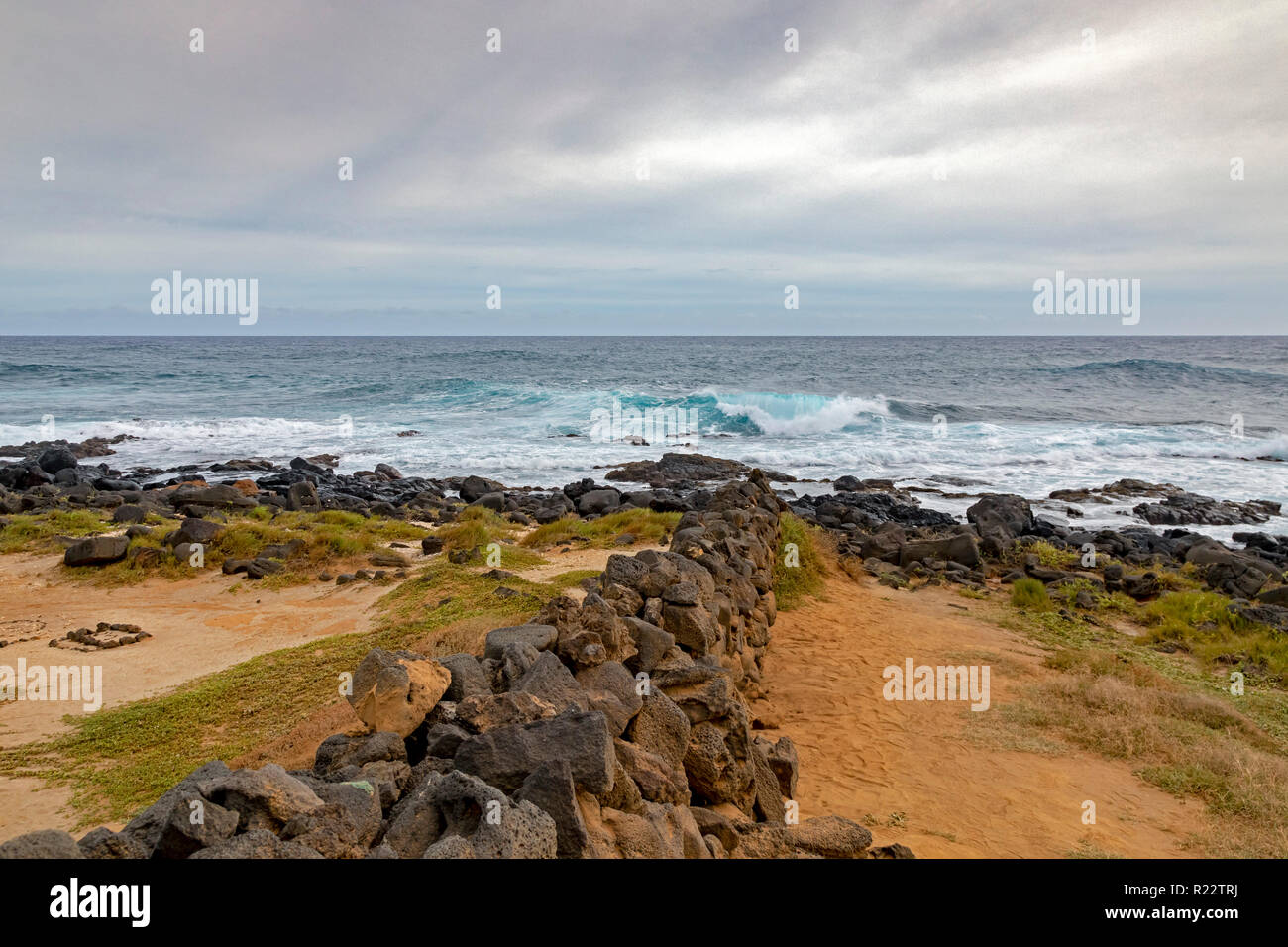 Ka Lae, Hawaii - A stone wall leads to the Pacific Ocean at the southernmost point in the United States, also called South Point, on Hawaii's Big Isla Stock Photo