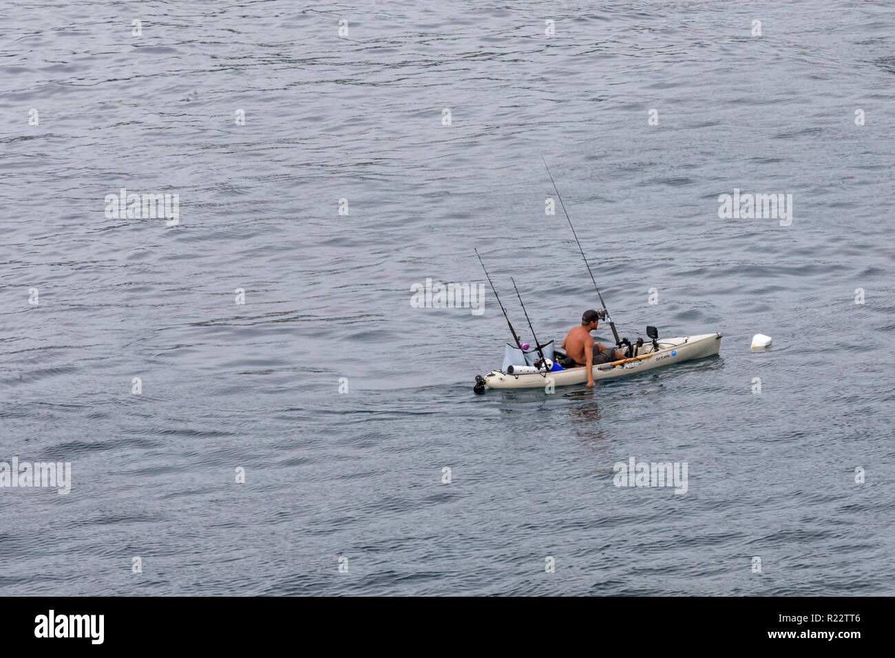 Ka Lae, Hawaii - A man fishes from a kayak near the southernmost point in the United States, also called South Point, on Hawaii's Big Island. Stock Photo