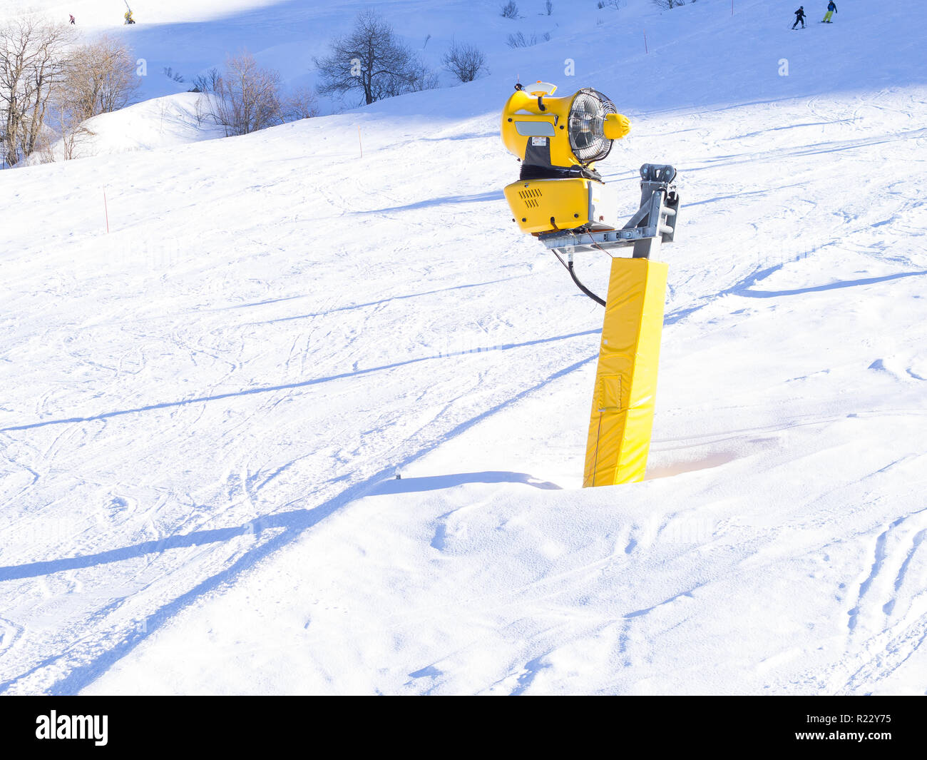 Yellow snow cannon on the ski slopes. Artificial snow making ...