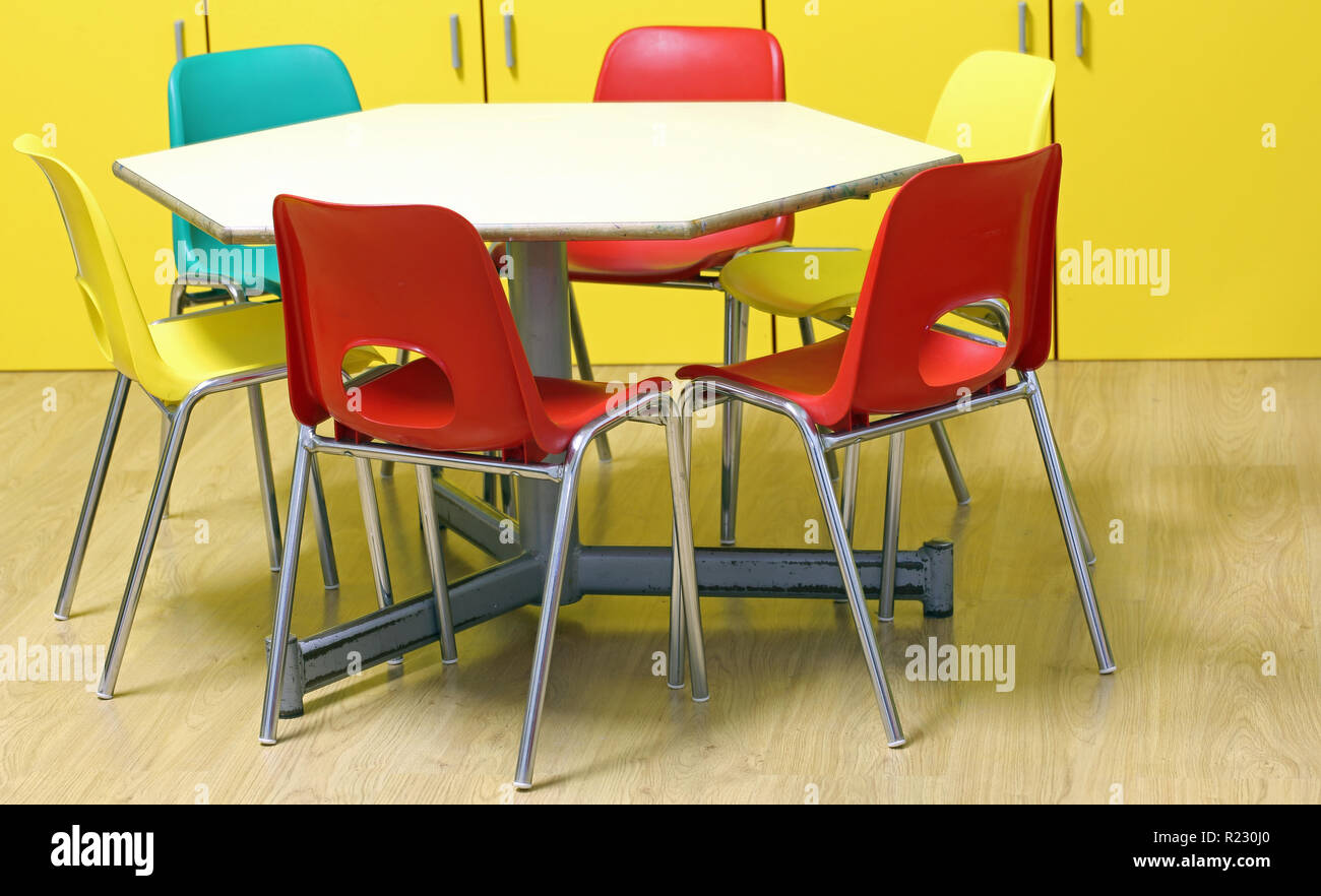 small colored chairs of a kindergarten classroom without children with wooden floor Stock Photo