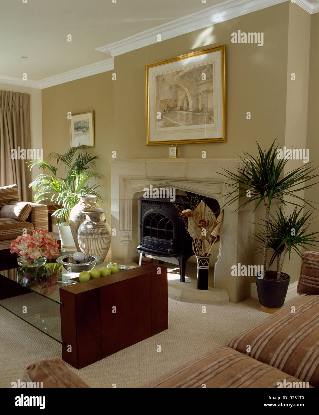 Glass+wood coffee table in front of living room fireplace Stock Photo