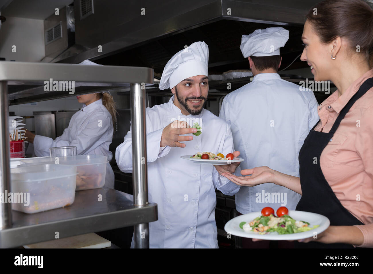 Head chef checking dishes in kitchen of restaurant before serving ...