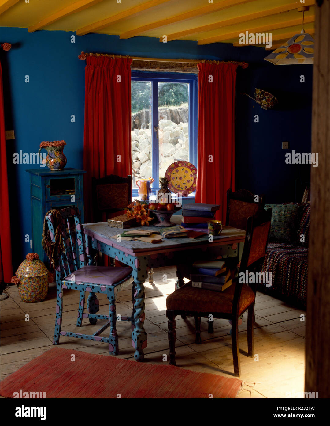 Colourfully painted table and chairs in bright blue dining room Stock Photo