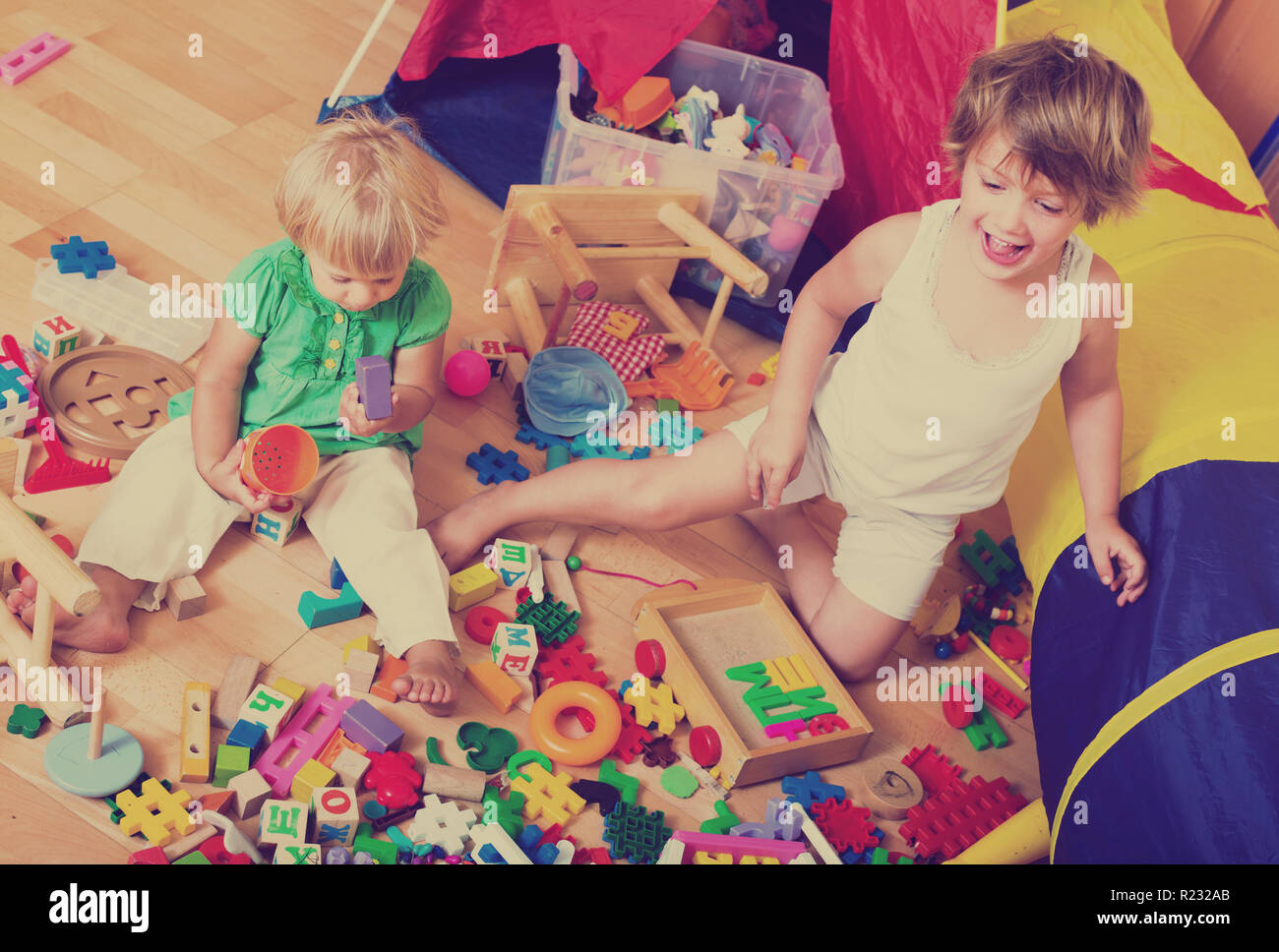 Two cute little girls playing with blocks in home interior Stock Photo ...