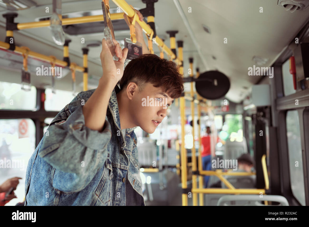 People, lifestyle, travel and public transport. Asian man standing inside city bus. Stock Photo