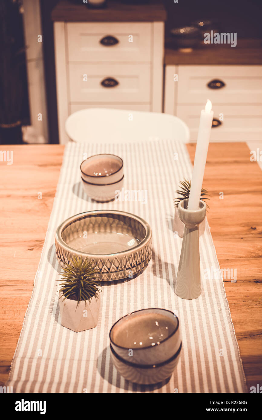 Plates And Decorative Candle On A Wooden Table In The Kitchen