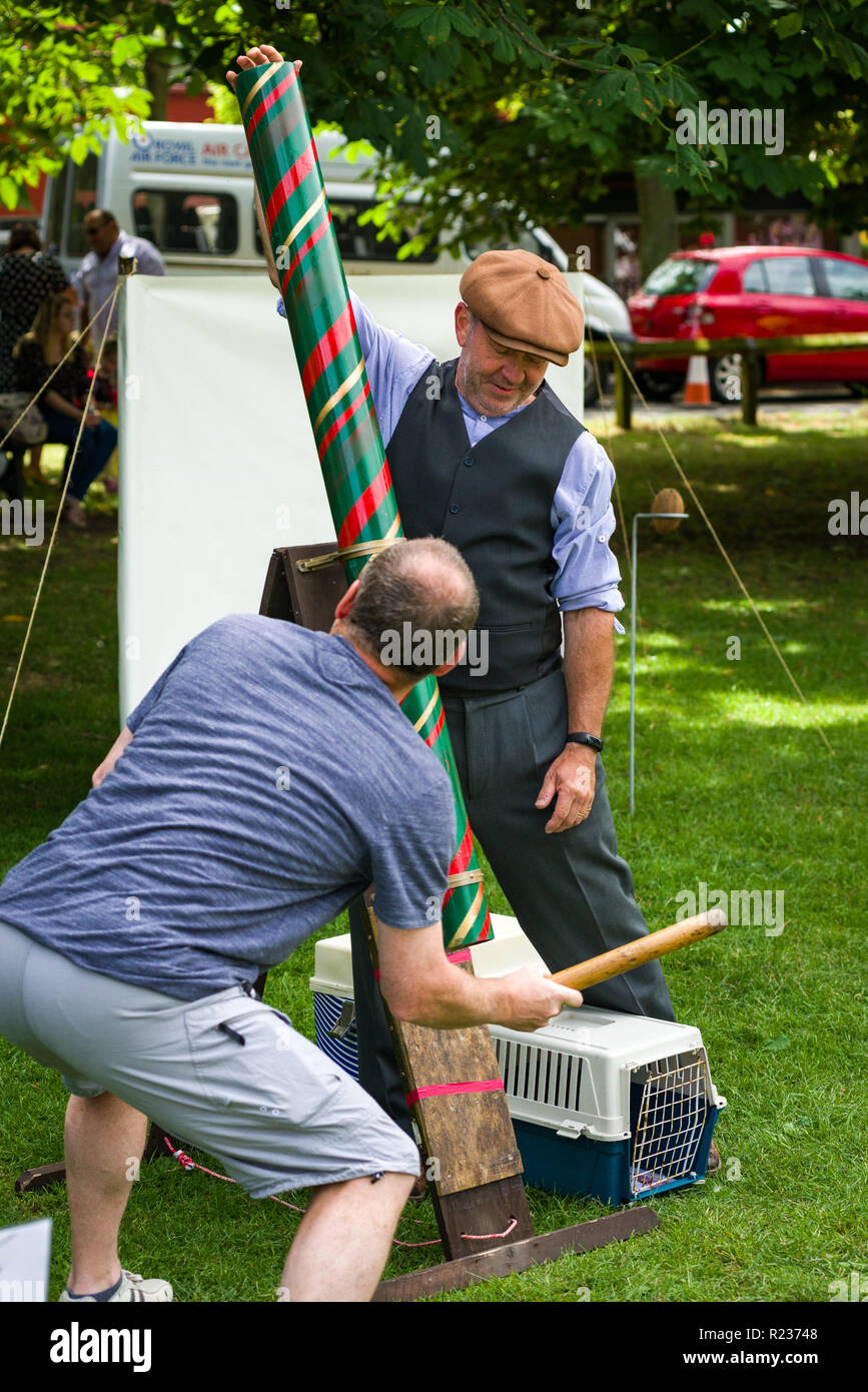 A man trying to win at a game of Splat the Rat with the stall holder ready to drop the rat, Brampton, UK Stock Photo