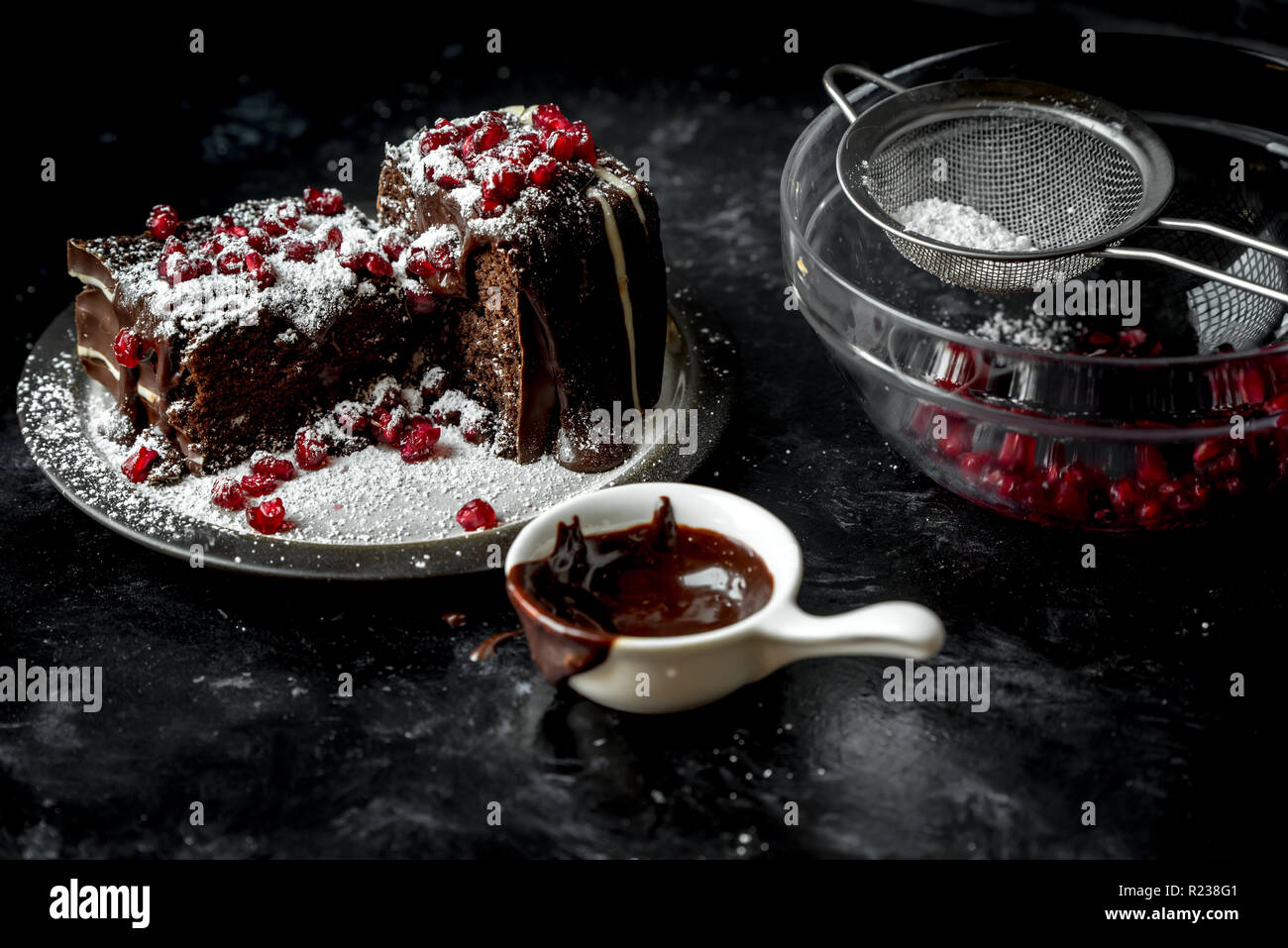 sweet moments - brownies poured hot, liquid chocolate, sprinkled with red pomegranate seeds and powdered sugar Stock Photo