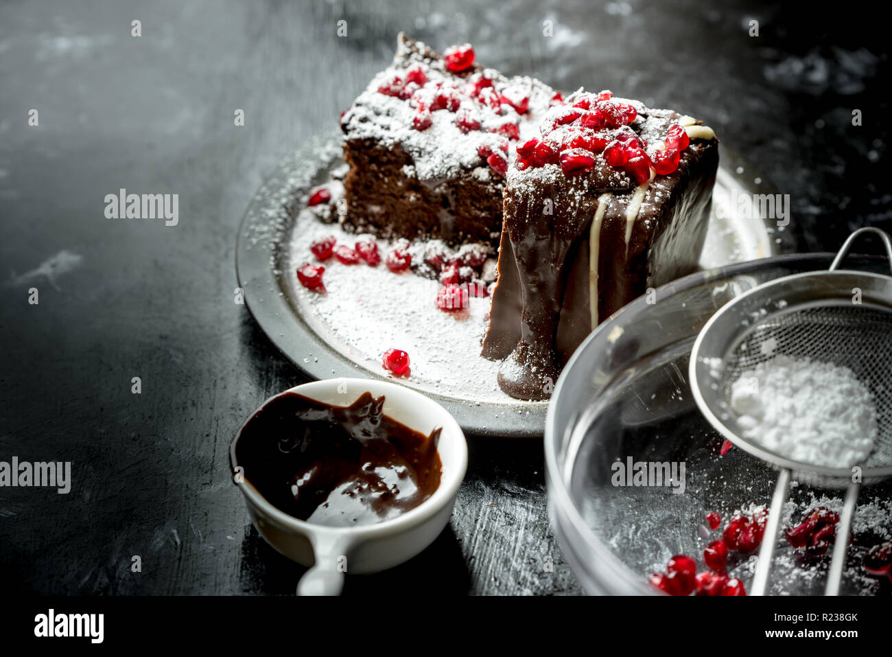 sweet moments - brownies poured hot, liquid chocolate, sprinkled with red pomegranate seeds and powdered sugar Stock Photo