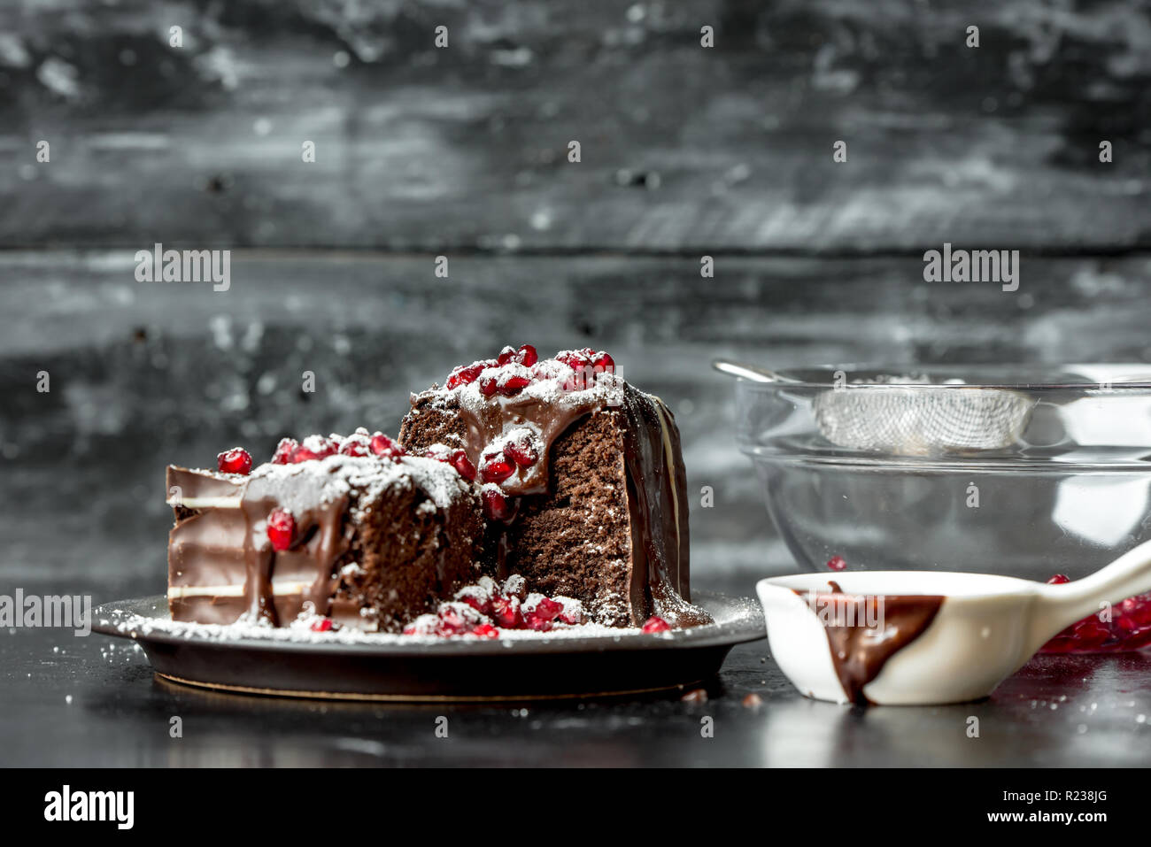 sweet moments - brownies poured hot, liquid chocolate, sprinkled with red pomegranate seeds and powdered sugar Stock Photo