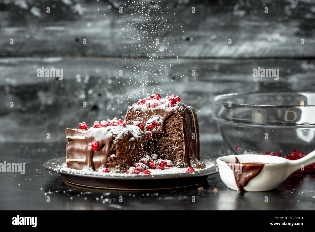 sweet moments - brownies poured hot, liquid chocolate, sprinkled with red pomegranate seeds and powdered sugar Stock Photo