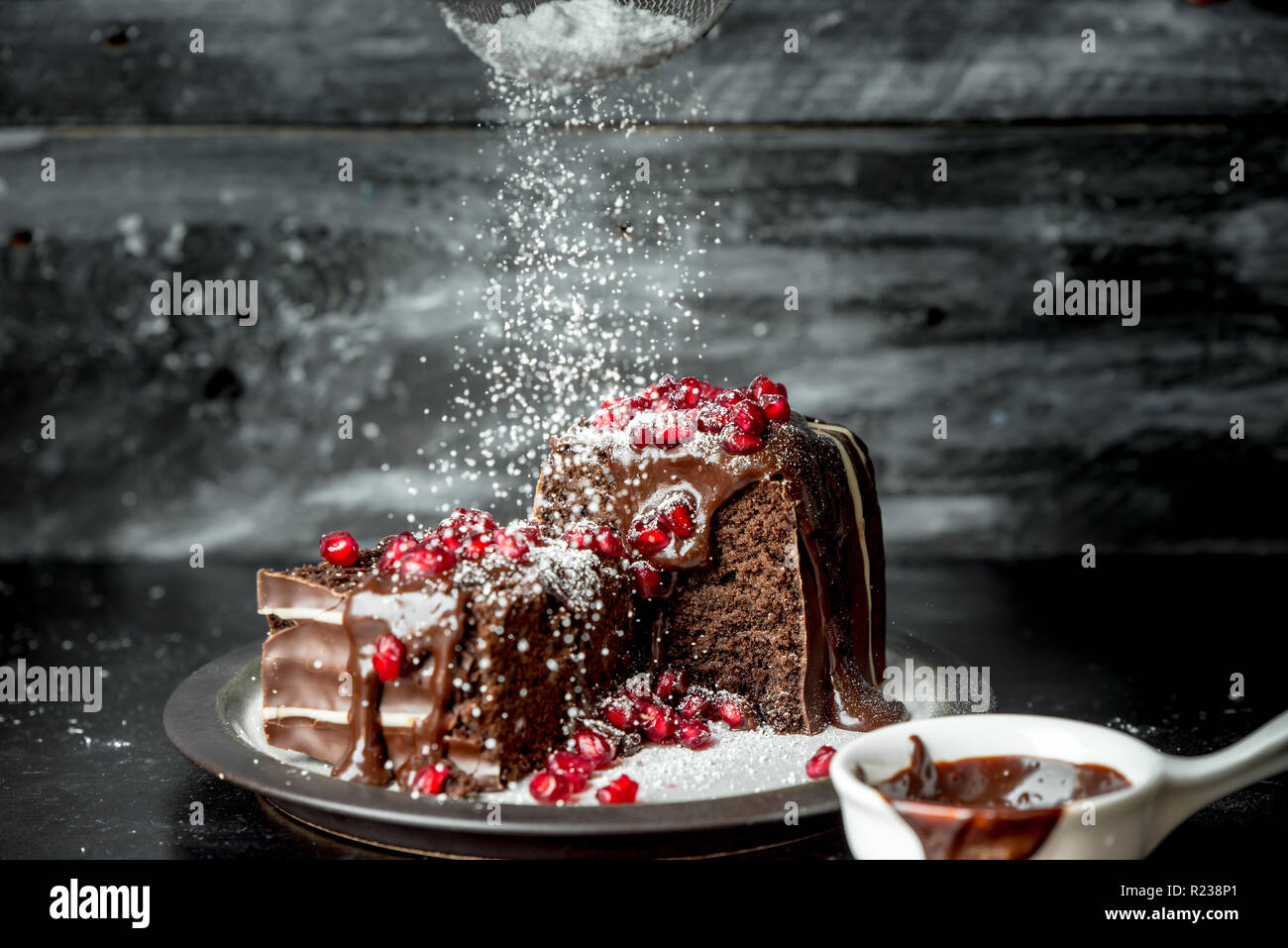 sweet moments - brownies poured hot, liquid chocolate, sprinkled with red pomegranate seeds and powdered sugar Stock Photo