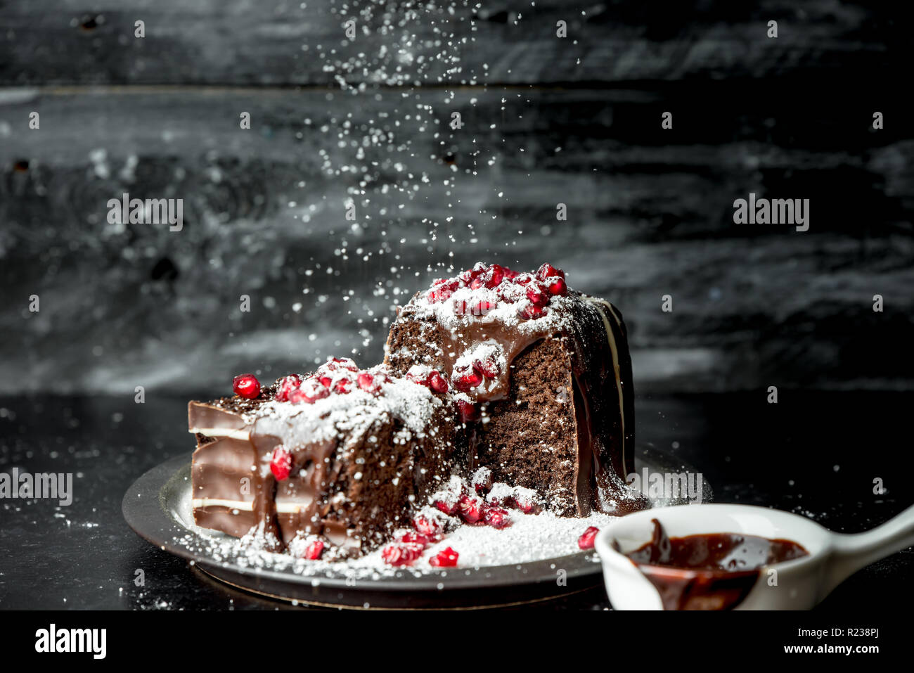 sweet moments - brownies poured hot, liquid chocolate, sprinkled with red pomegranate seeds and powdered sugar Stock Photo