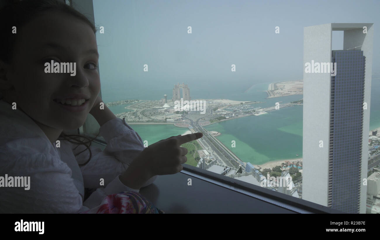 Teenage girl looks through Abu Dhabi telescope from observation deck Stock Photo